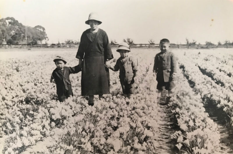 Sadame Mori and her sons walking among their field of freesias