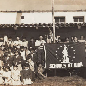Students at Aliso School holding banner that says "Schools at War"