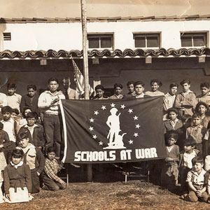 Students at Aliso School holding banner that says "Schools at War"